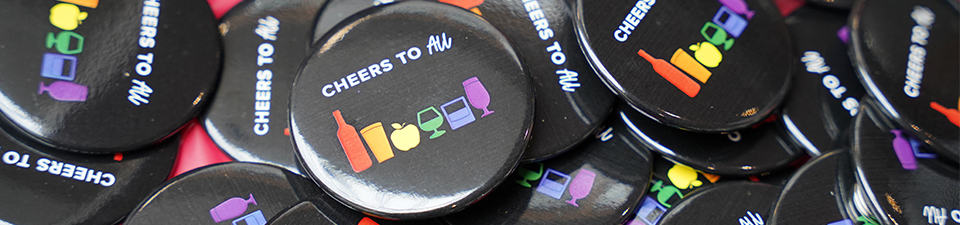 A collection of NSLC pride buttons saying "cheers to all."