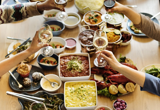 Four friends toasting over a potluck dinner