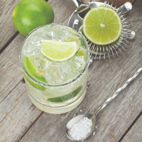 Clear liquid in a cocktail glass garnished with a lime wheel